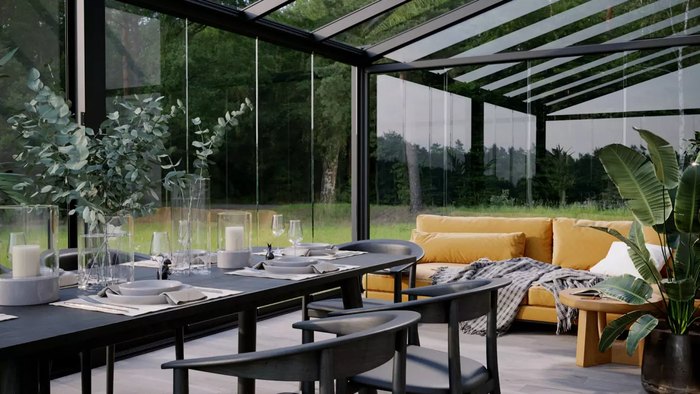 Intérieur d’un jardin d’hiver aménagé en salle à manger et salon