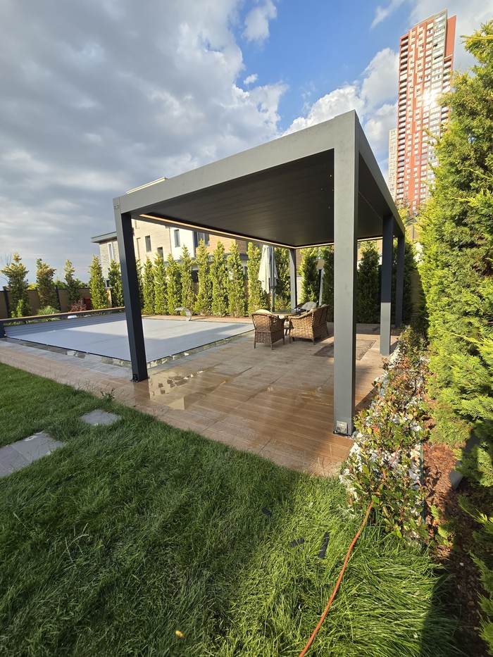 Pergola autoportée dans un jardin avec salon d’extérieur